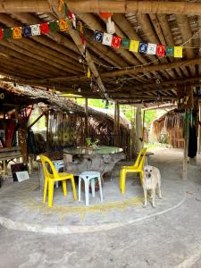 a dog standing in front of a table and chairs at Tribal Huts Community in Malapascua Island +46 photos