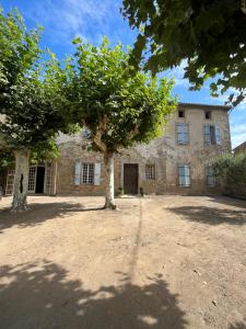 a large stone building with a tree in front of it at Les 3 Platanes in Conilhac-Corbières