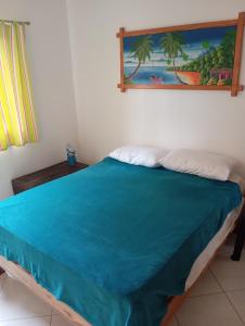 a bed in a room with a painting on the wall at Caoba in Las Terrenas +22 photos