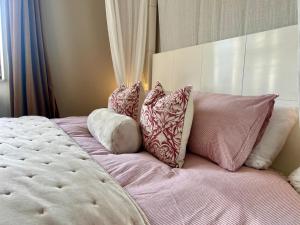 a bed with four pillows on top of it at Waterside Cabin in Belturbet