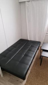 a black bed in a room with a window at Economy stay - Self Check-in in Vaasa