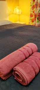 a bedroom with a bed with pink towels on it at Stylish Rose Garden Apartment with Balcony & Parking in Asenovgrad