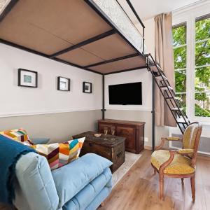a living room with a blue couch and a tv at Superbe Grand Studio dans le vieux Tours avec fraicheur au rendez-vous in Tours