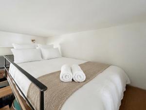 a bedroom with a bed with two towels on it at Superbe Grand Studio dans le vieux Tours avec fraicheur au rendez-vous in Tours