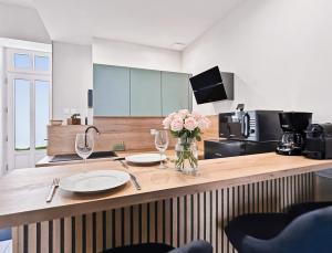 a kitchen with two glasses and a vase of flowers on a counter at Superbe Grand Studio dans le vieux Tours avec fraicheur au rendez-vous in Tours