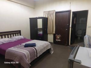 a bedroom with a bed with a purple blanket at Redbull guest house in Pattaya
