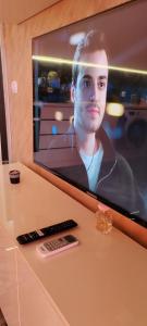 a tv on a table with a remote control at Stylish Rose Garden Apartment with Balcony & Parking in Asenovgrad