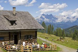 a group of people sitting in a fence in front of a barn at T-Lodge Zauchensee in Altenmarkt im Pongau
