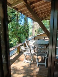 a wooden deck with a table and chairs on it at Morada Sunset Vista Para o Mar in Praia do Rosa