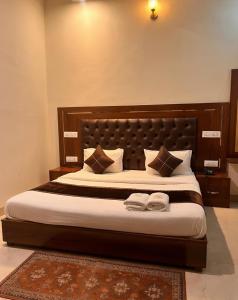 a bedroom with a large bed with two towels on it at Hotel WoodCresstt Zirakpur !! Budget Friendly Stay With Airport Access in Zirakpur