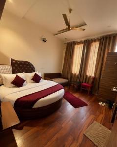 a bedroom with a large bed with a ceiling fan at Hotel WoodCresstt Zirakpur !! Budget Friendly Stay With Airport Access in Zirakpur