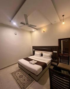 a bedroom with a bed with a ceiling fan at Hotel WoodCresstt Zirakpur !! Budget Friendly Stay With Airport Access in Zirakpur