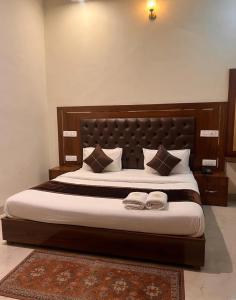 a bedroom with a large bed with two towels on it at Hotel WoodCresstt Zirakpur !! Budget Friendly Stay With Airport Access in Zirakpur +2 photos