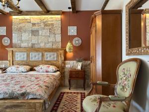 ein Schlafzimmer mit einem Bett und einem Stuhl in der Unterkunft Apartments Villa Mike in Mostar + 116 Fotos