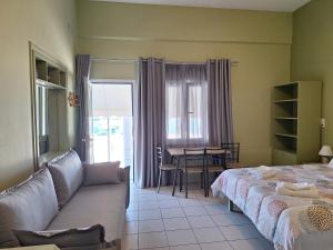 a living room with two beds and a table and a couch at Myrto in Tyros