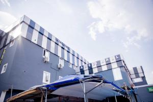 a building with a blue umbrella in front of it at Dee Rocket Hotel & Lounge in Ibadan