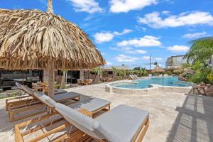 a resort with a pool and a straw umbrella at NÔA Curacao in Willemstad
