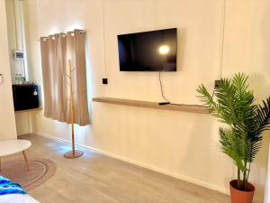 a living room with a tv on a wall at Sunvada Beach Rayong in Rayong