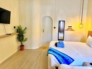 a bedroom with two beds and a potted plant at Sunvada Beach Rayong in Rayong