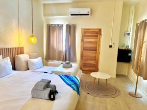 a hotel room with two beds and a table at Sunvada Beach Rayong in Rayong