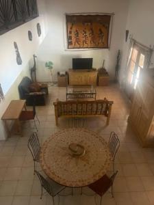 a living room with a table and chairs at Superbe villa avec piscine privée à 500m de la plage à Nianing in Nianing