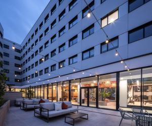 a building with couches and chairs in a courtyard at Amro Pamplona - Albergue Juvenil in Pamplona
