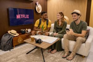 a group of three people sitting on a couch at 12H Hostel in Al-ʿUla