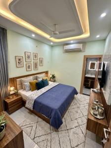 a bedroom with a large bed with a blue blanket at Mangalam Palace Vrindavan in Chhatikara