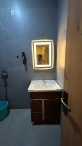 a bathroom with a sink and a mirror at Mangalam Palace Vrindavan in Chhatikara