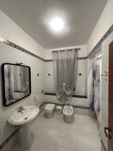 a bathroom with a sink and a toilet and a mirror at Residence Il Melograno in Lampedusa
