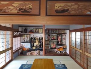 a room with a table and shelves with toys at ゲストハウス青い輝き in Marugame