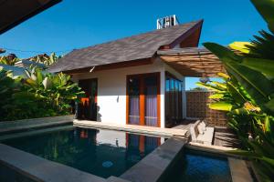 a small house with a swimming pool in front of it at INNerpeace Bali in Darmasaba