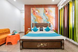 a bedroom with a bed with a painting on the wall at Hotel Brij Stone in Vrindāvan +44 photos