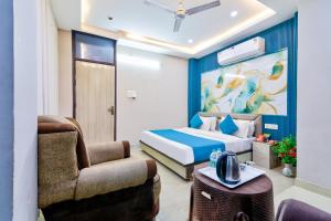 a hotel room with a bed and a chair at Hotel Brij Stone in Vrindāvan
