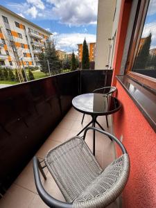a table and a chair on a balcony at Mirror Loft - Coresi District in Braşov