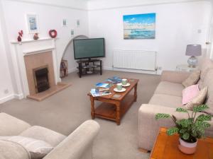 a living room with two couches and a television at Weymouth Bay Apartment C in Weymouth