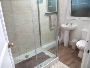 a bathroom with a shower with a toilet and a sink at Weymouth Bay Apartment C in Weymouth +26 photos