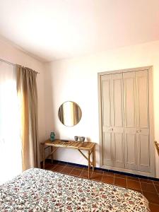 a bedroom with a bed and a mirror and a table at Suite Triana in El Rocío