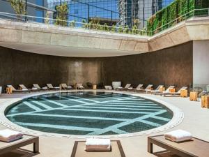 a large pool in a building with chairs and tables at SLS Buenos Aires Puerto Madero in Buenos Aires