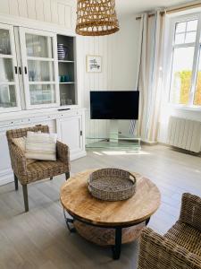 a living room with a table and a tv at LES POIS SONT ROZ in Perros-Guirec