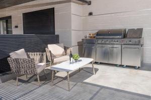 a patio with a grill and a table and chairs at רויאל בוטיק טווינס 2 in Safed