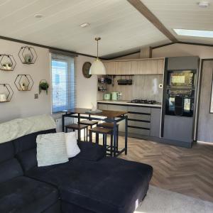 a living room with a black couch and a kitchen at 10 Sunset view in Scunthorpe