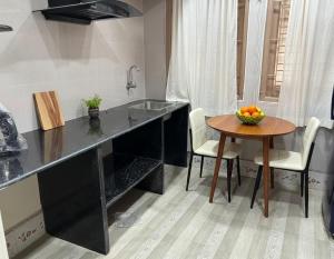 a kitchen with a counter and a table with a bowl of fruit at Veda Home's B in Agartala