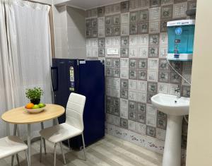 a bathroom with a table and a blue refrigerator at Veda Home's B in Agartala
