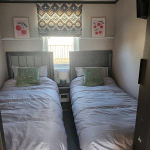 two beds in a small bedroom with a window at 10 Sunset view in Scunthorpe