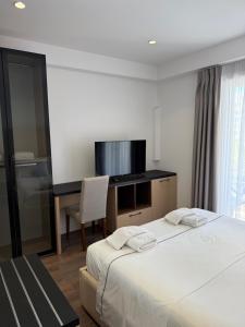 a bedroom with a bed and a desk with a television at Adria Palace Hotel & SPA in Durrës