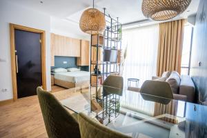 a living room with a glass table and a bedroom at Apartment Jungle in Belgrade +4 photos
