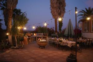 a patio with tables and chairs at night with lights at Orpheus Inn & Glamping in Kaneb Pos