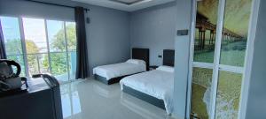 a bedroom with two beds and a large window at Restu Chalet Tioman in Tioman Island +54 photos