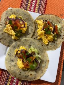 three omelet breakfast tacos on a white plate at Casa Hostal Amar-illa in El Valle +38 photos